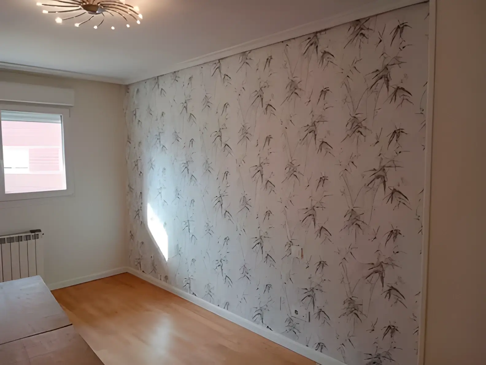 El Pintor en Cádiz colocando papel pintado en pared de acento de habitación luminosa