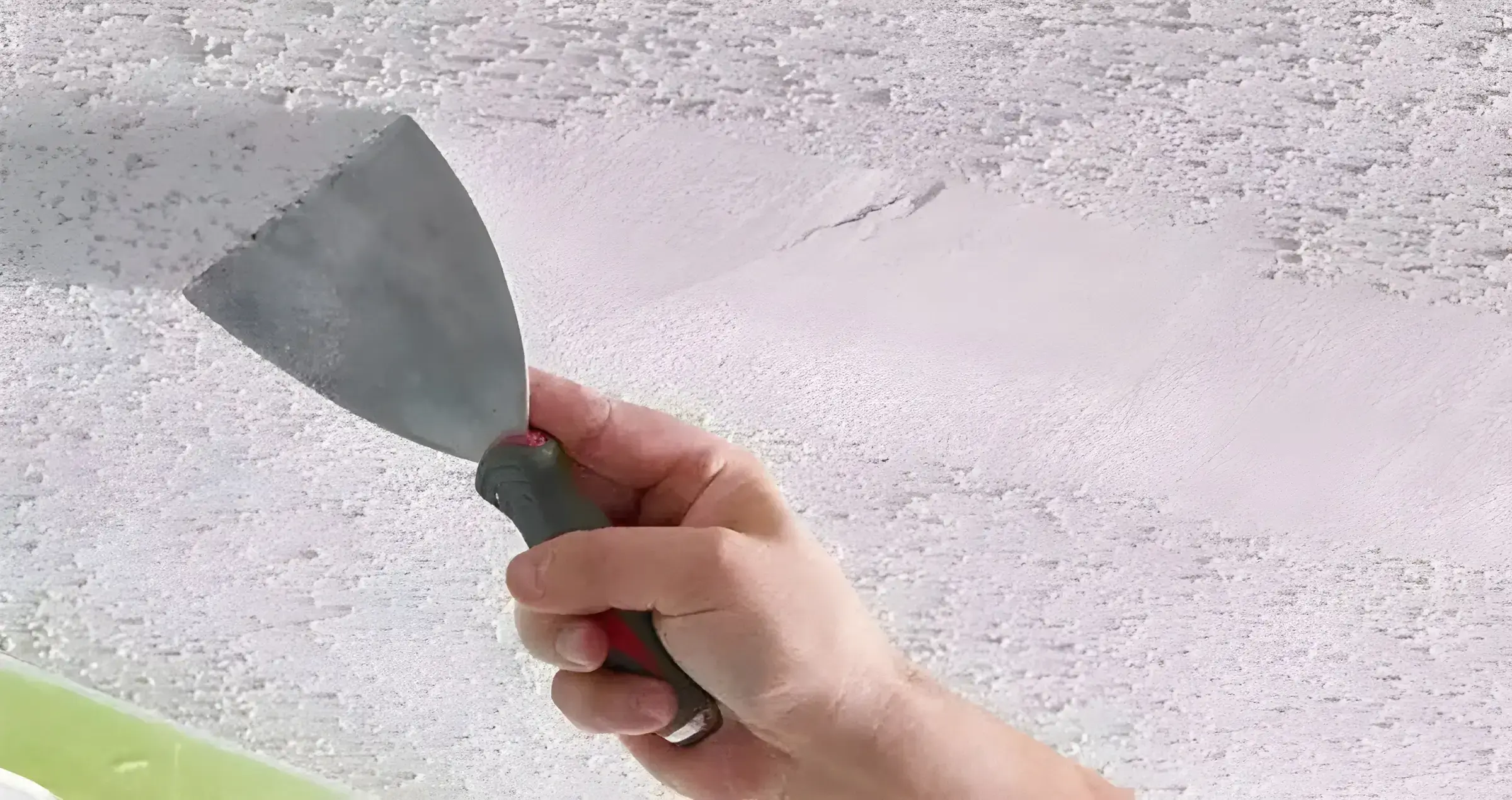 El Pintor en Cádiz eliminando el gotelé con espátula para dejar la pared lisa